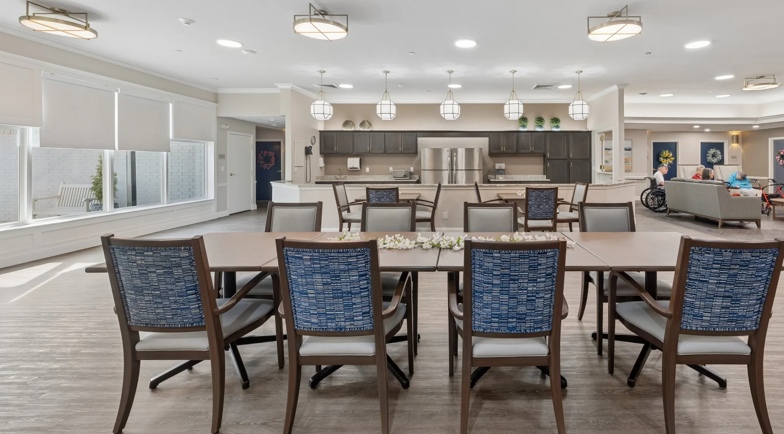 Memory care dining room with elegant blue chairs and open kitchen