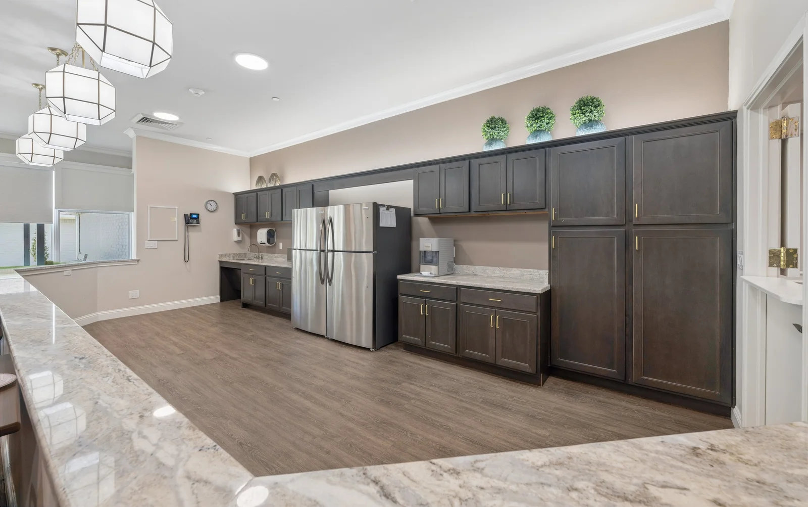 Modern memory care kitchen with dark cabinets and granite counters